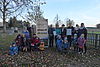 Eine Gruppe von Kindern und Erwachsenen haben sich für ein Gruppenfoto auf dem Kitagelände zusammengestellt.